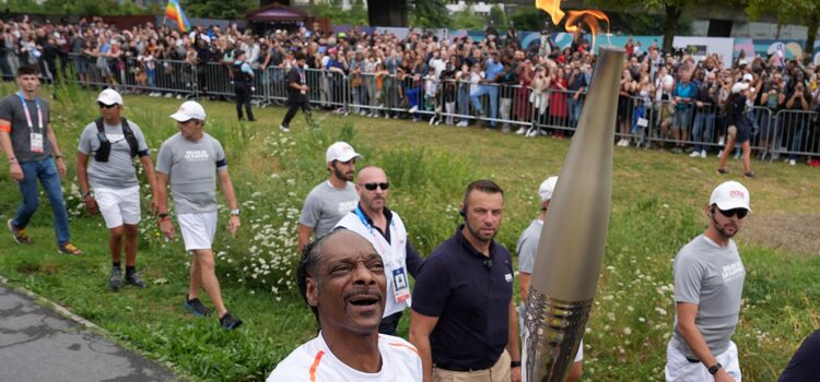 Snoop Dogg Carries Olympic Torch Through Paris Suburb